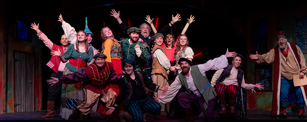 A scene from "Something Rotten" showing the full cast.